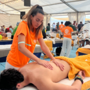 Alumna realizando masaje a deportista en el Ironman Lanzarote 2026