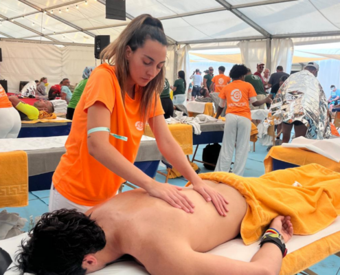 Alumna realizando masaje a deportista en el Ironman Lanzarote 2026