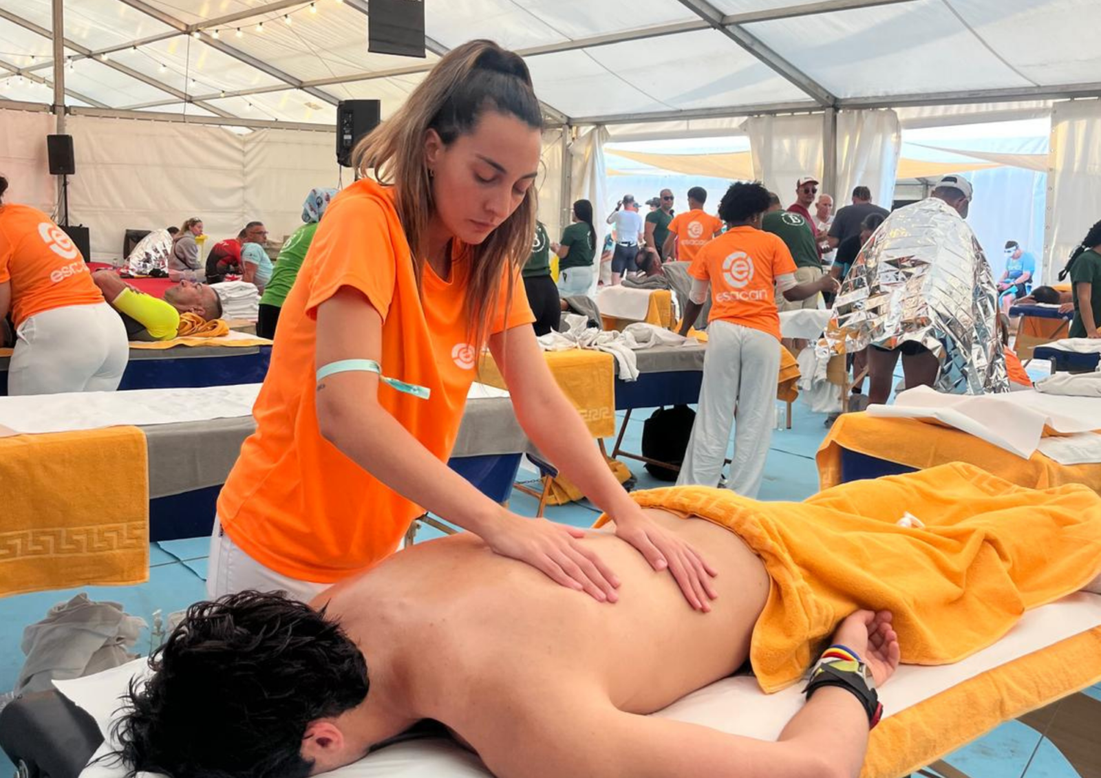 Alumna realizando masaje a deportista en el Ironman Lanzarote 2026