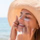 Mujer usando crema solar en el Rostro